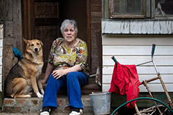 woman and dog sitting on front porch steps