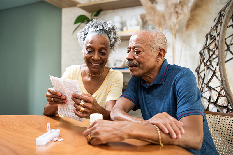 older couple sitting at table looking at paperwork