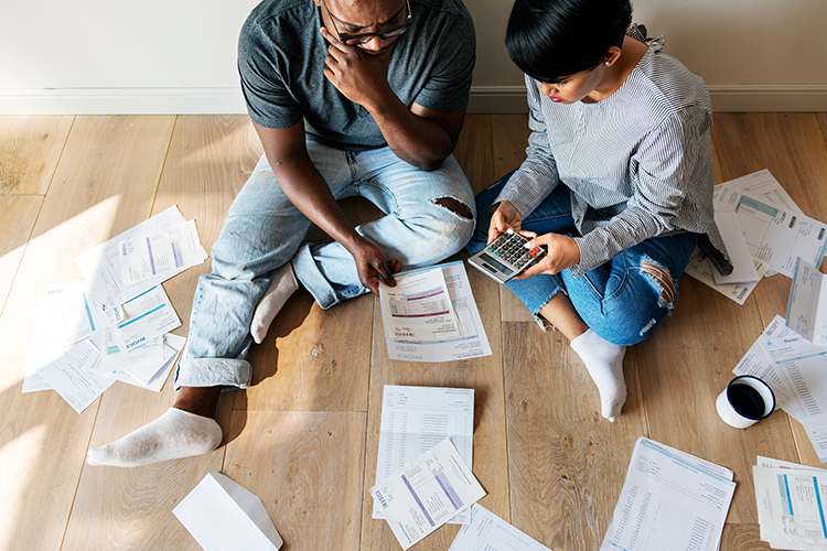 Couple on floor with calculator looking at bills