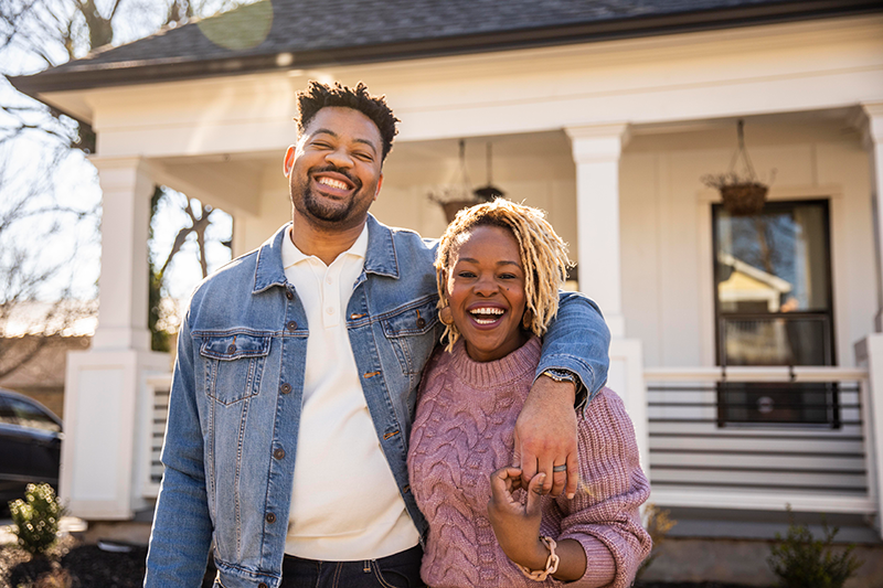 couple standing in front of house