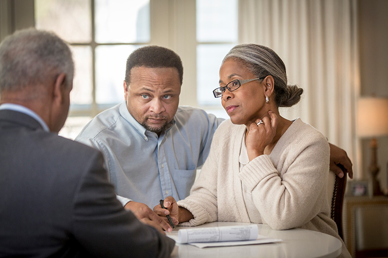 woman and man sitting at a table across from lawyer