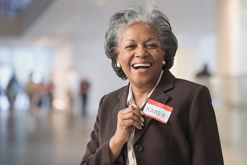 woman smiling at the camera with a name tag on her jacket