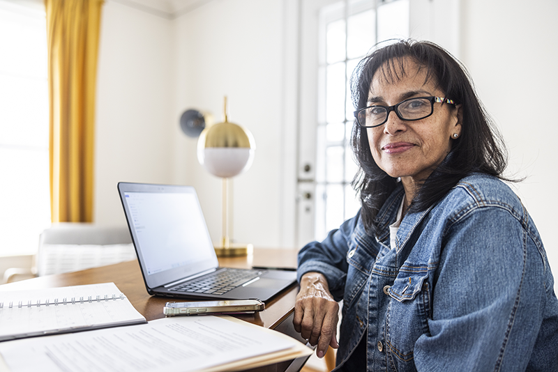 woman sitting at desk with computer looking at camera
