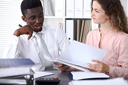 man and woman looking at papers together