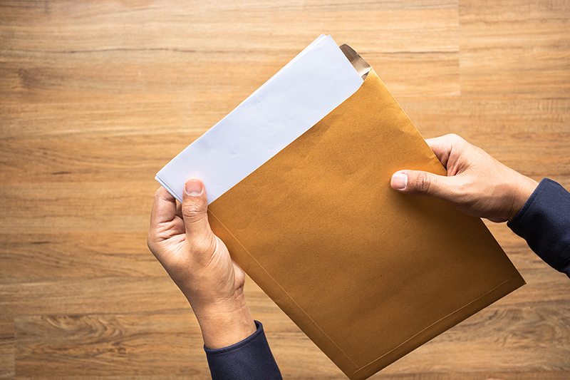 mans hands holding large envelope