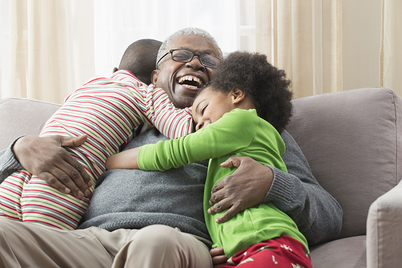 two kids hugging man on couch