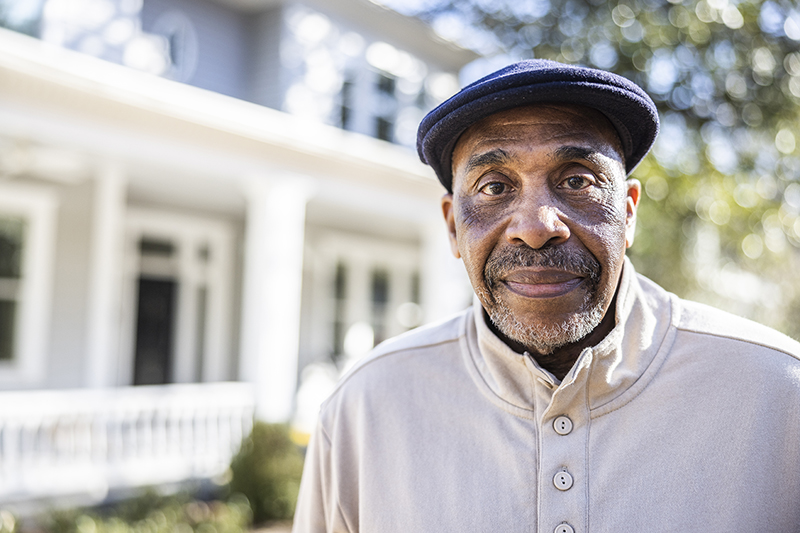 older man standing outside looking at camera