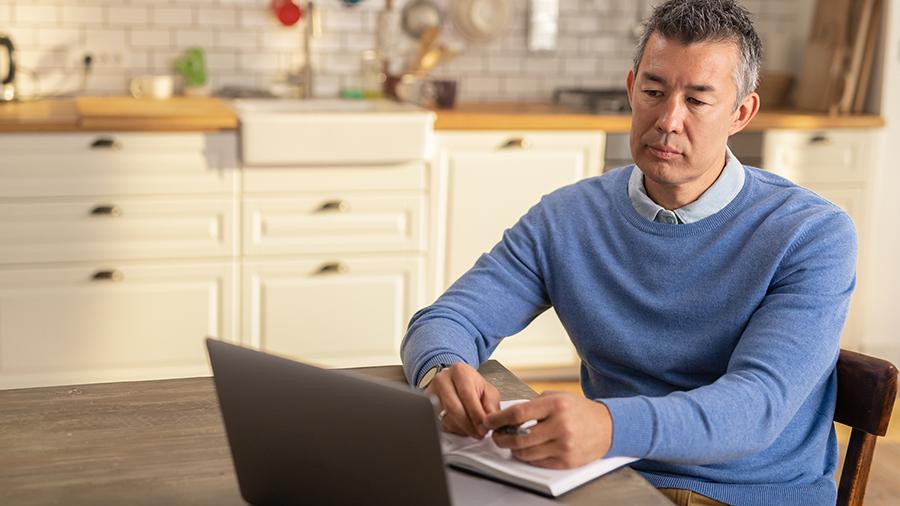 Man at table looking at computer